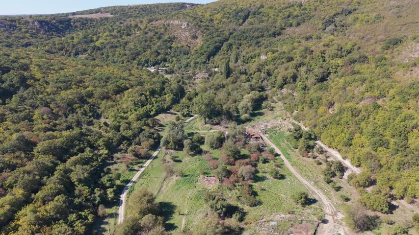 Beautiful aerial landscape showing lush vegetation, wooded hills, and winding paths through nature.