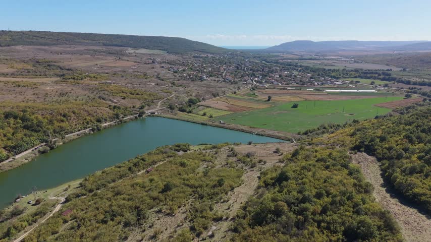 Beautiful aerial landscape featuring green water, winding shoreline, trees, and peaceful surroundings.