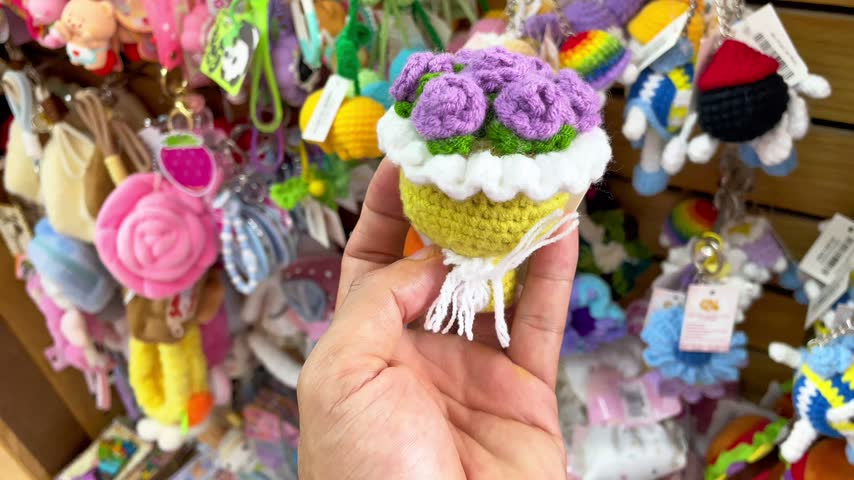 A cute handmade crochet flower bouquet keychain held in a person