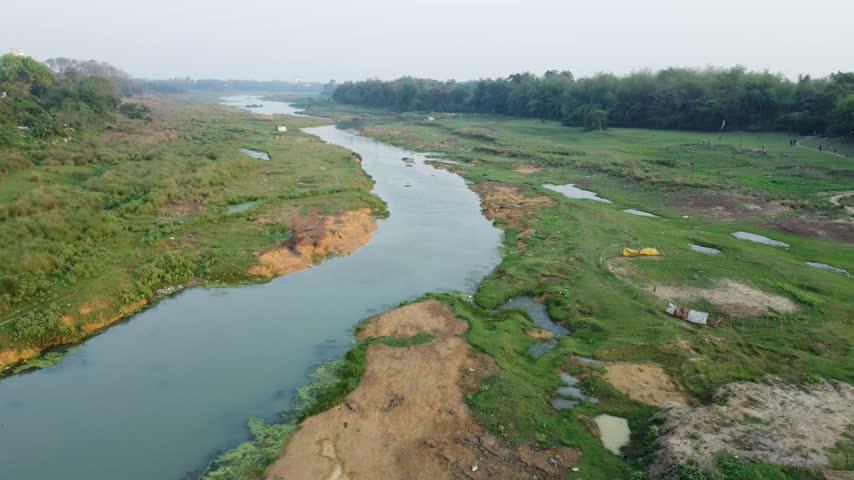 Trees have grown on both banks of a dying river.
