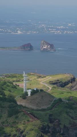Songaksan Mountain Peak Coastline Overlooking Coastal Waters And Islets Near Hwanguchi Beach In Daejeong-eup, Seogwipo, Jeju Island, South Korea. - aerial vertical shot