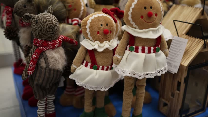 Christmas gingerbread dolls and festive reindeer toys decorate a store display creating a cozy holiday atmosphere with charming characters for winter gifts and home decor