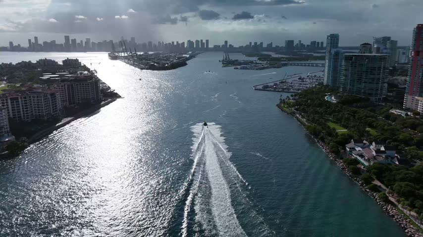Aerial view of a boat cruising through the channel at Miami Beach with the city skyline in the background, Miami-Dade County, Florida, United States.