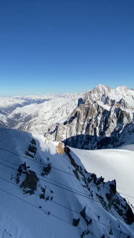 Warm sunrise light spills over snow-covered Alpine peaks in winter. A serene, high-altitude landscape with glowing ridges and peaceful mountain atmosphere.