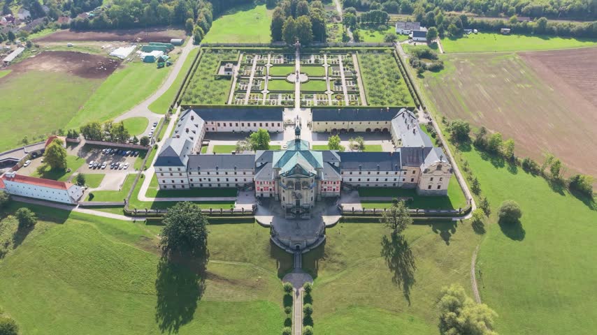 Aerial view of the historic Hospital Kuks surrounded by manicured gardens and green fields in Kuks, Kralovehradecky kraj, Czechia.