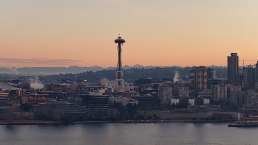 Drone flight above the Seattle Space Needle at sunset above downtown skyline and mountains, Washington, USA. g.