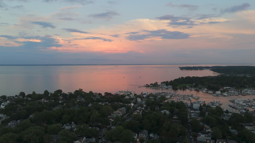 Sunset Sky Reflected Over Chesapeake Bay Waters, Annapolis Coastal Neighborhoods, And Waterfront Marinas in Maryland, USA. - aerial shot