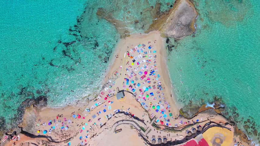 High-altitude shot of the picturesque Ibiza coastline surrounded by clear blue sea.