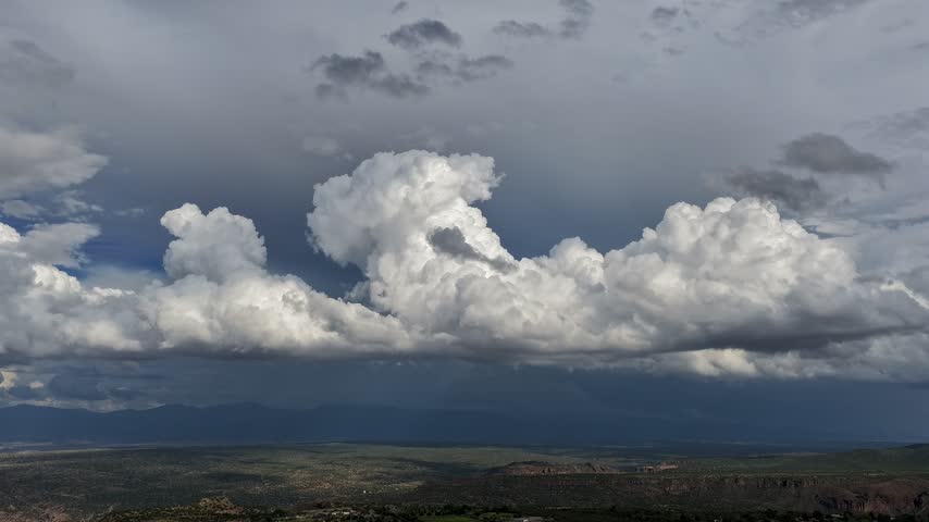 Aerial view of low hanging rolling stormy clouds over a high desert canyon landscape with ominous skies in White Rock, NM, United States.