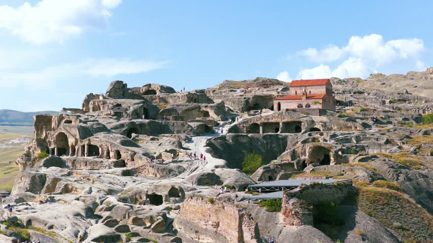 Uplistsikhe Ancient Rock-hewn Town With Cave Dwellings And Carved Chambers Near Gori In Eastern Georgia. Aerial Ascending Shot