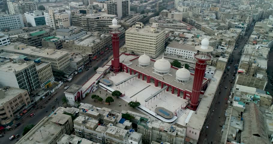 Aerial view of Memon Masjid with its distinctive red minarets and white domes surrounded by the dense urban landscape of Karachi, Sindh, Pakistan.