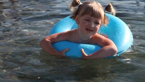 Pretty little girl swimming with inflatable circle