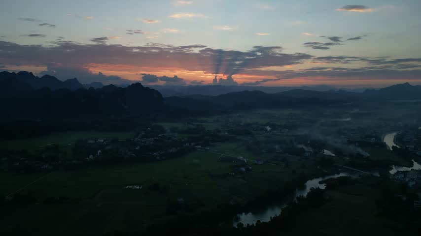 Sunset over riverside valley with mountains