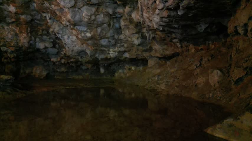 Cave with reflective water surface and rocky walls