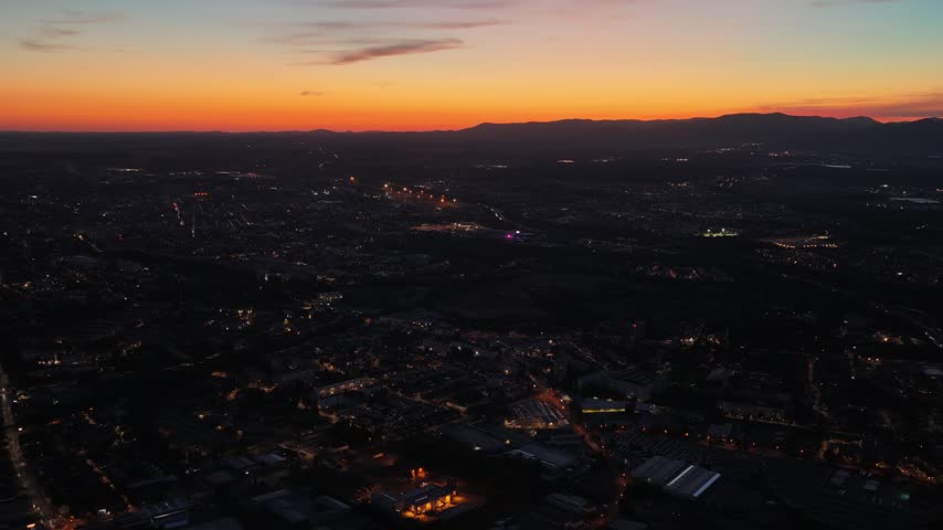 Aerial view of Mulhouse at night with glowing city lights under a vibrant sunset sky Mulhouse, Grand Est, France.