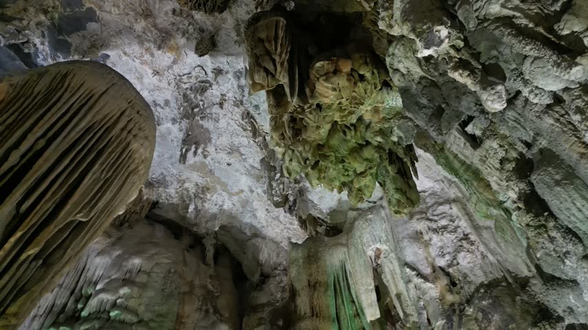 Limestone cave formations with green moss