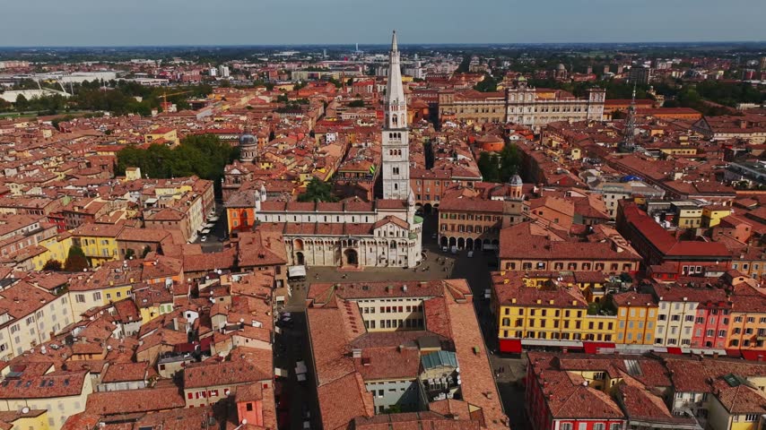 Aerial drone view of Modena Cathedral, Duomo di Modena, in Italy, showcasing its Romanesque architecture, historic rooftops, Piazza Grande, and the heart of Modena old town.