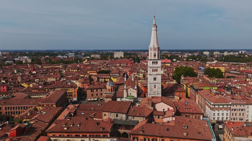 Aerial drone view of Modena Cathedral, Duomo di Modena, in Italy, showcasing its Romanesque architecture, historic rooftops, Piazza Grande, and the heart of Modena old town.