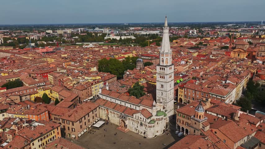 Aerial drone view of Modena Cathedral, Duomo di Modena, in Italy, showcasing its Romanesque architecture, historic rooftops, Piazza Grande, and the heart of Modena old town.