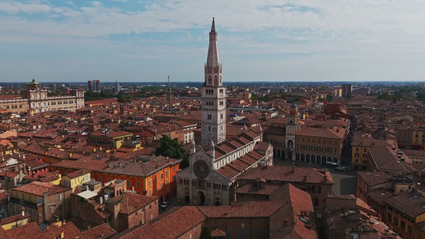 Aerial drone view of Modena Cathedral, Duomo di Modena, in Italy, showcasing its Romanesque architecture, historic rooftops, Piazza Grande, and the heart of Modena old town.