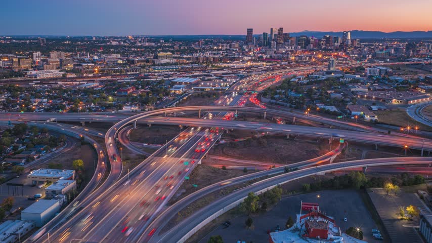 Aerial view of the busy highway interchange with light trails from traffic at sunset in Denver, Colorado, United States.