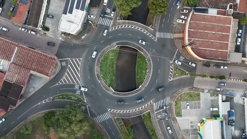 Aerial view of a busy roundabout with cars navigating the intersection and green landscaping in the center in Araras, Sao Paulo, Brazil.