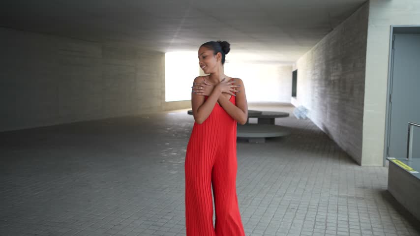 In a minimalist setting, a confident female model poses in a bold red outfit, highlighting modern fashion innovations and current trends, showcasing her chic elegance and graceful demeanor