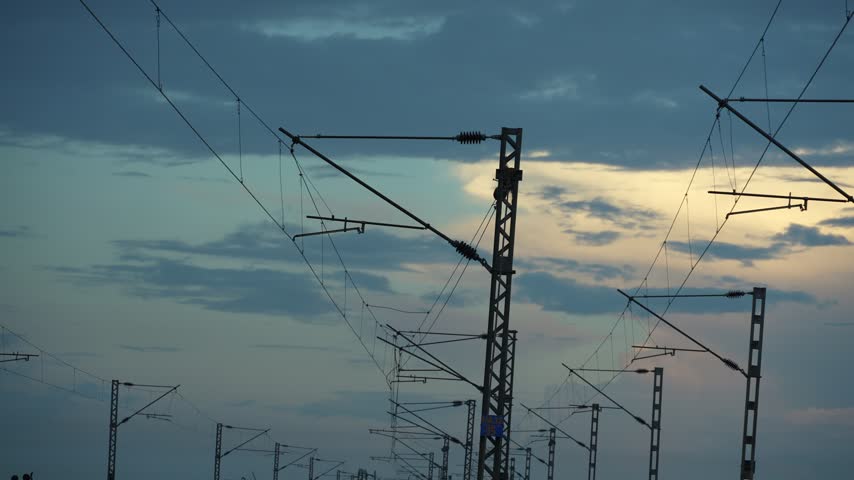 Overhead train wires amidst the autumn sunset