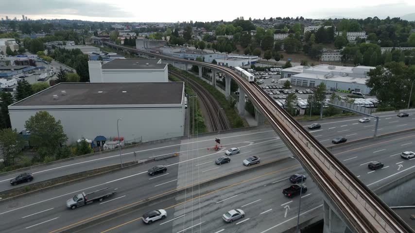 Elevated Light Rail Transit Bridge Spanning Over The Highway In Burnaby, BC, Canada. - aerial shot
