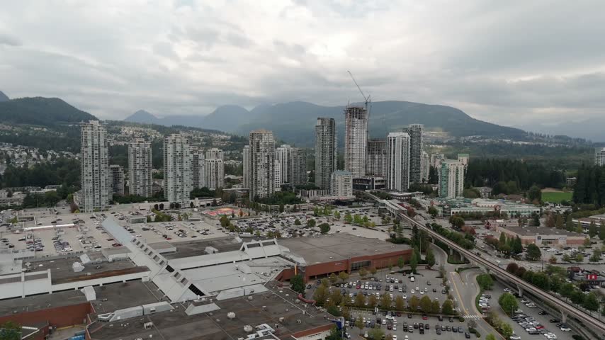 Coquitlam Centre Mall Parking Lots, Highrise Towers And SkyTrain Elevated Track In Canada. - aerial shot