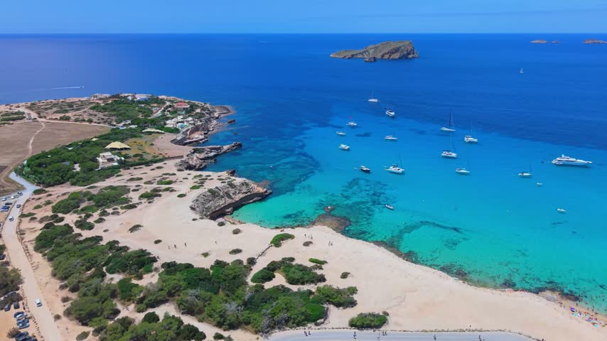 Aerial view of calm turquoise ocean waters and coastal rocks along Ibiza.