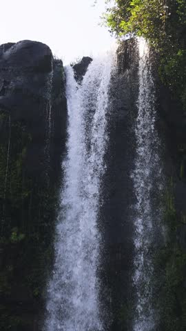 Jeongbang waterfall in Seogwipo, Jeju island, Jeju-do, South Korea, water streams falling over a dark basalt cliff into a pool by the sea on a sunny day, nature and volcanic landscape, Seogwipo-si

