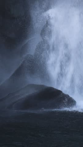 Jeongbang waterfall in Seogwipo, Jeju island, Jeju-do, South Korea, water streams falling over a dark basalt cliff into a pool by the sea on a sunny day, nature and volcanic landscape, Seogwipo-si
