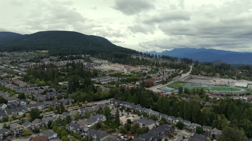Suburban Residential Houses And School And Running Track Under Construction In Burke Moutnain, Coquitlam, BC, Canada. - aerial shot