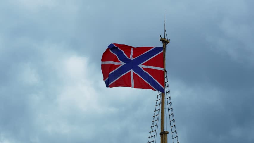 Russian naval jack and fortress flag on a mast against stormy sky
