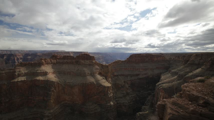 Grand Canyon rim clouds drifting over layered red rock timelapse.
