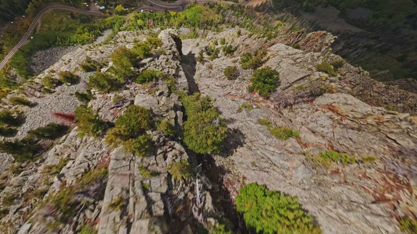 Aerial view of rugged rocky cliffs and winding mountain roads in Telluride, Colorado, United States.