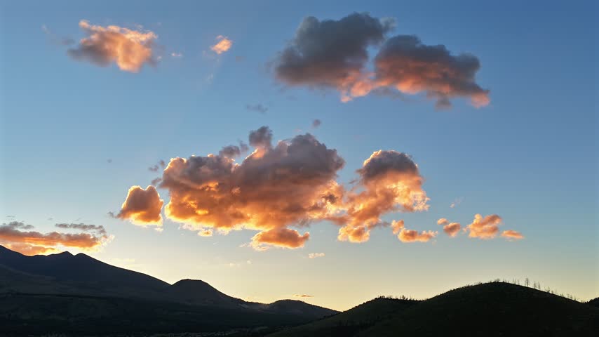 Aerial view of golden clouds drifting over the San Francisco Peaks during sunset in Flagstaff, Arizona, United States.