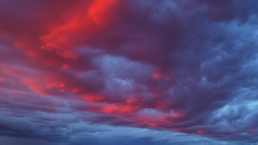 Aerial view of crimson storm clouds shifting to blue in the sky over Los Alamos, New Mexico, United States.