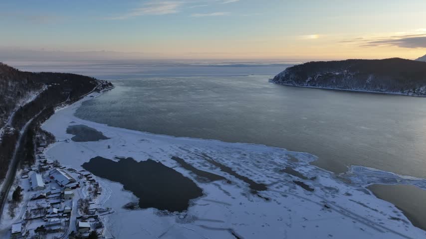 Aerial View of Forested Cape and Open Water of Baikal at Dusk