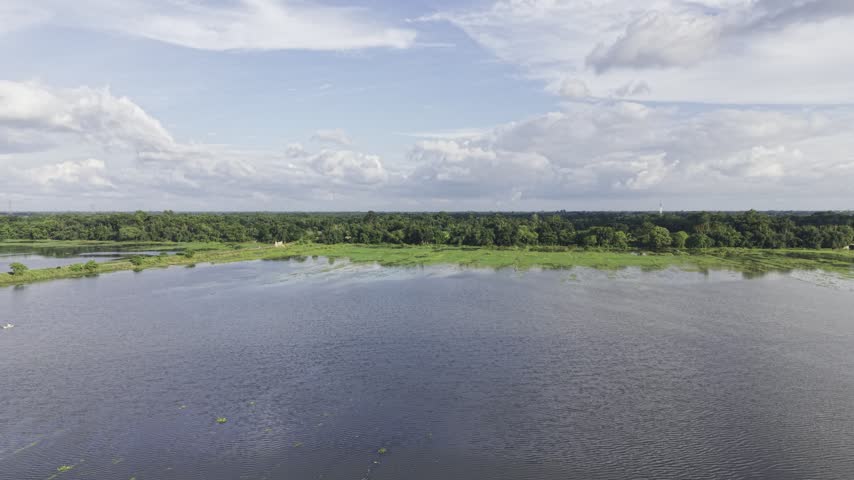 Scenic wetland landscape featuring open water, irregular green vegetation along the water