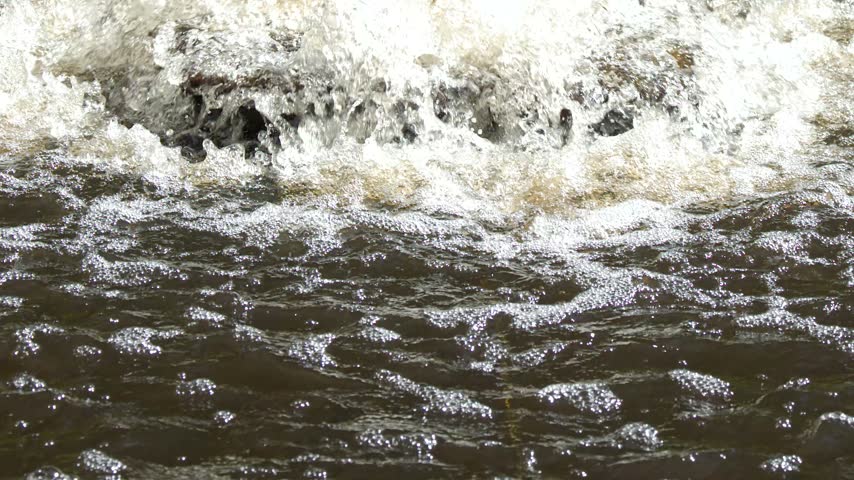 Close-up of churning water bubbling and splashing from an outdoor pond aeration fountain.