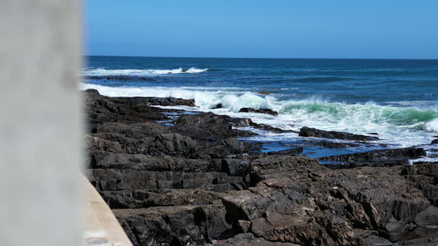 Ocean waves crashing on rocky coastline along the promenade in Cape Town