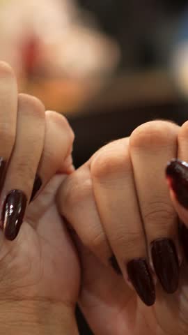 Close Up of Woman’s Hands with Dark Burgundy Nail Polish