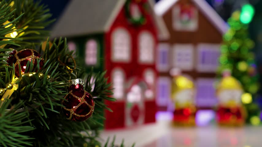A yellow car pulls up to two snowmen in the center of the Christmas village