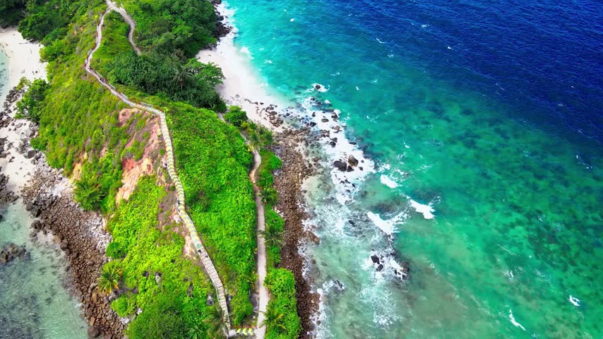 An aerial landscape view showcasing lush green mountains, dense forests, and a scenic lake nestled between the hills 