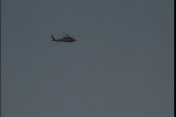 Helicopters fly behind the Art Deco tower of the Louisiana Capitol Building in Baton Rouge, Louisiana.