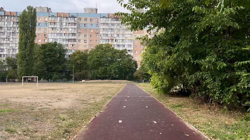 Outdoor Running Track in Residential Area with Apartment Building in Background
