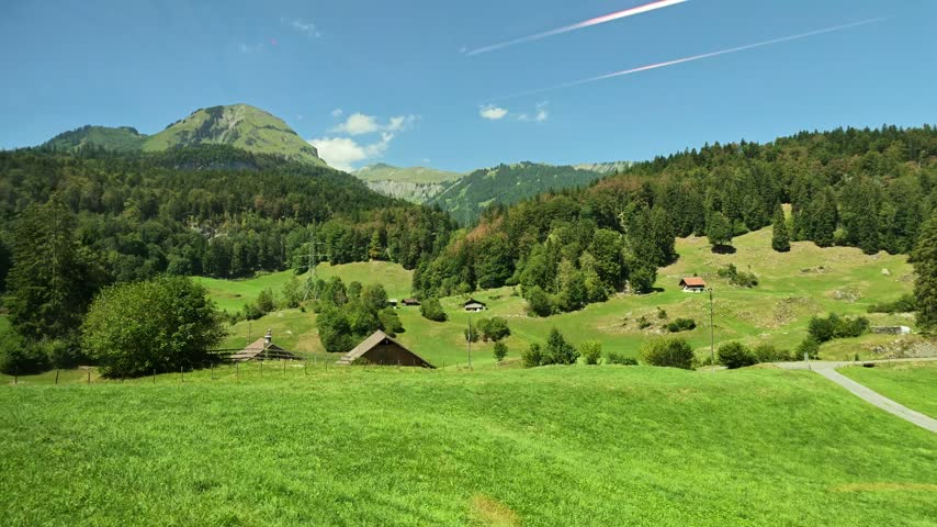 Panoramic Swiss Railway train passing through the rural farmlands and countrysides of the Brunig Pass heading towards the Jungfrau region of Switzerland.