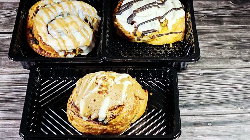 Pastries of a chocolate-drizzled cinnamon roll, a sweet pastry topped with white frosting and dark chocolate stripes, cinnamon roll, a sweet pastry consisting of a rolled sheet of yeast-leavened dough covered in a sweet cinnamon-sugar butter filling, topped with a creamy white icing and a caramel spread drizzle, Danish pastry, a flaky, buttery croissant-style dough base topped with cheesecake icing, a caramel and chocolate drizzle, biscuit cream paste and nuts